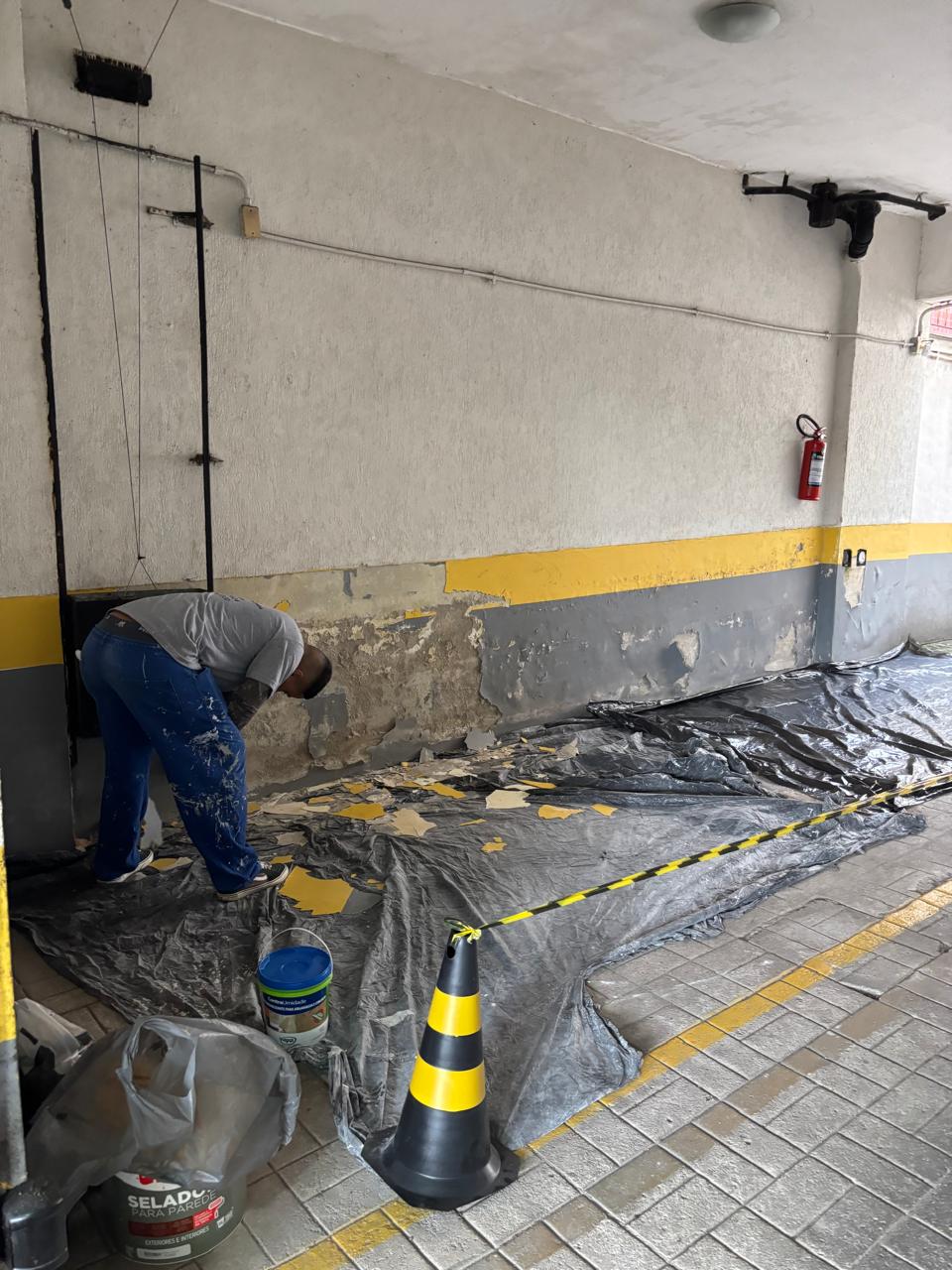 Profissional removendo pintura descascada por infiltração