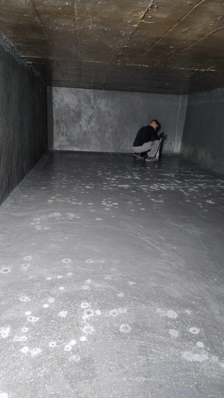 Profissional aplicando impermeabilizante em caixa d'água