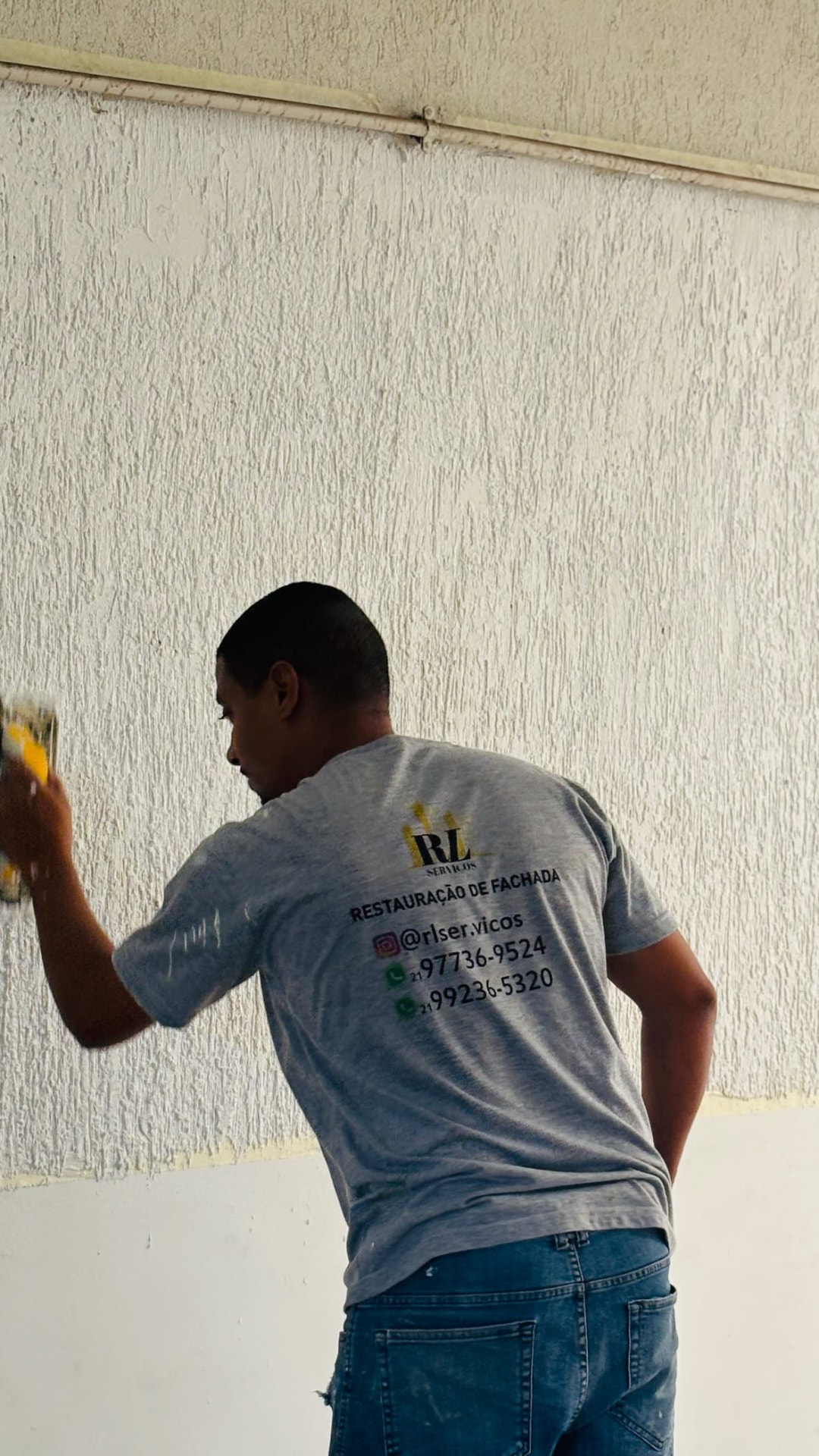 Profissional da RL Serviços aplicando pintura em parede texturizada